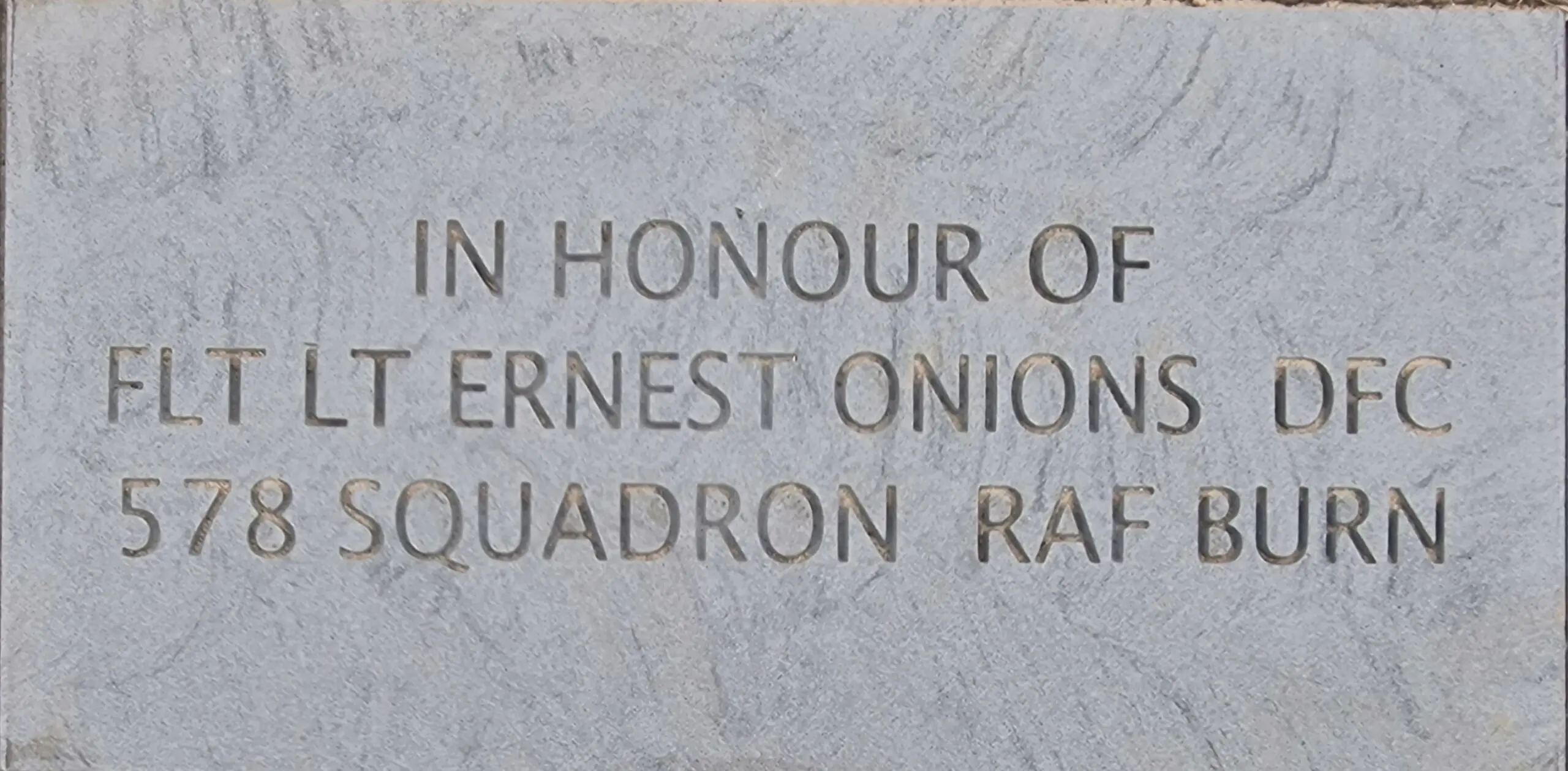 Colour photo of a stone laid in memory of Flt Lt Ernest Onions