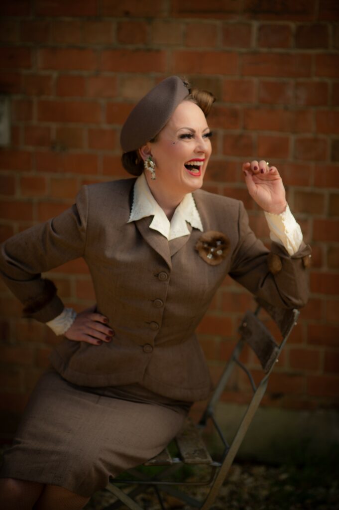 Mother's Day vintage tea singer Lil dressed in 40's outfit sitting on a chair