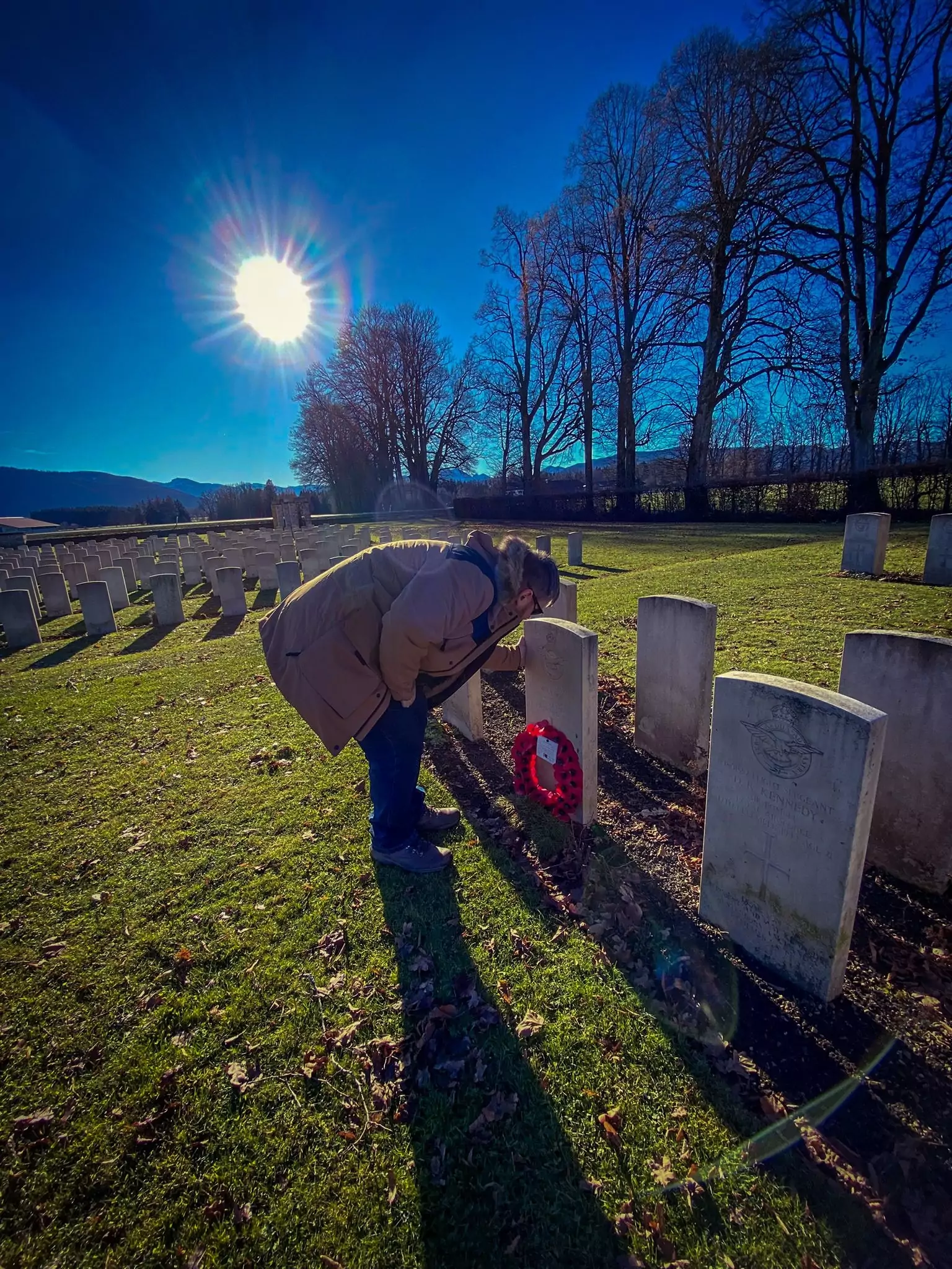 colour photo of a man at a war grave