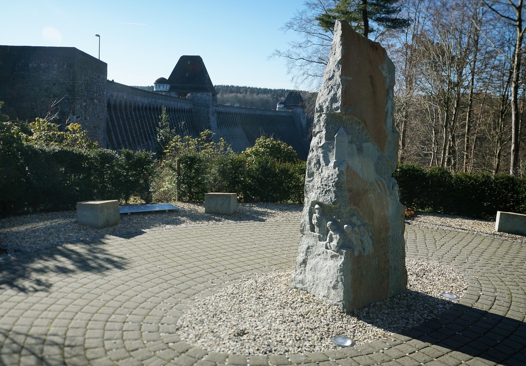 colour image of a stone memorial and the Mohne Dam, Germany